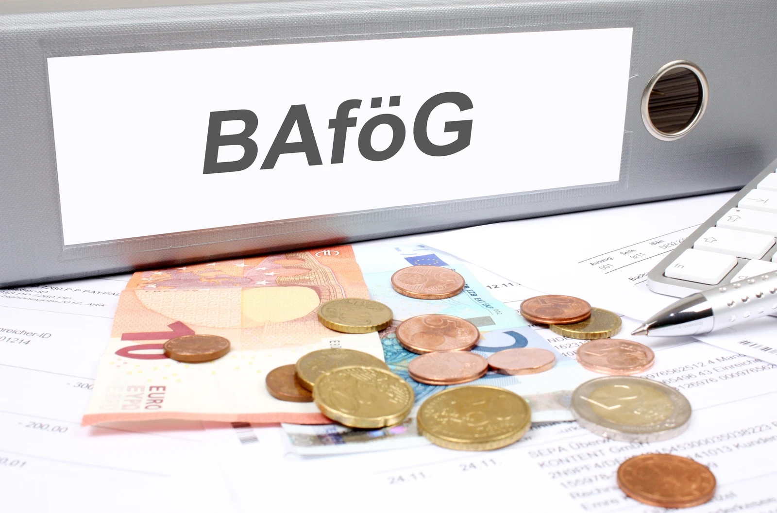 Geld und Ordner mit BAföG-Beschriftung: manQ unterstützt Dich bei der Beantragung