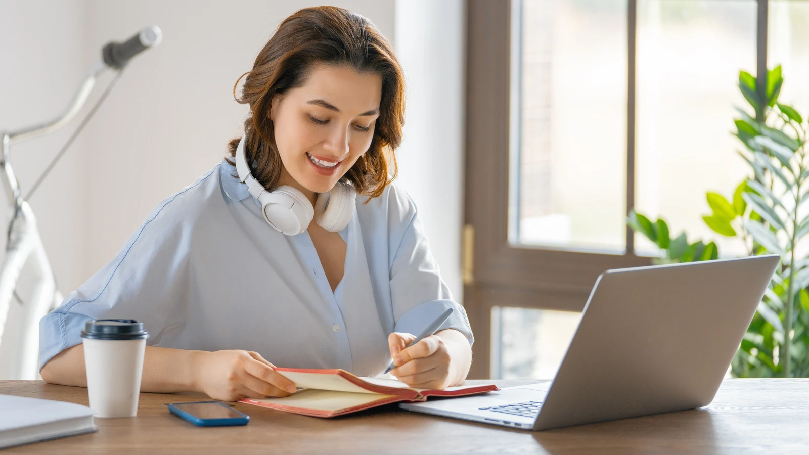 Frau mit Headset lernt mittels Videokonferenz