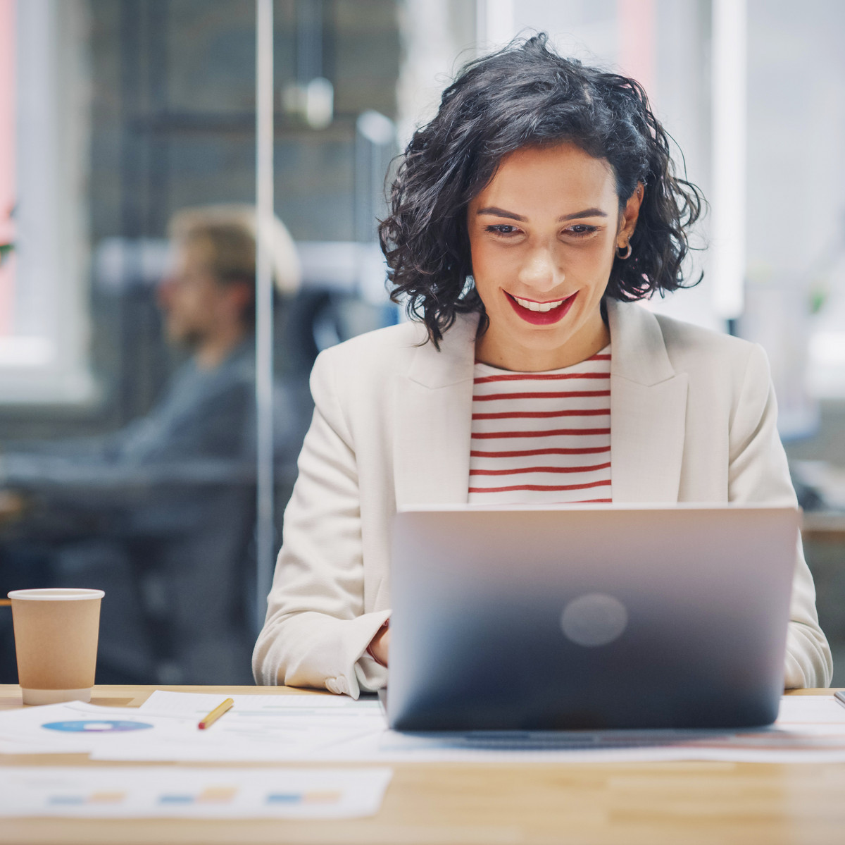 Geprüfte Fachwirtin für Marketing sitzt am Laptop und freut sich über den Erfolg der Marketing-Kampagne