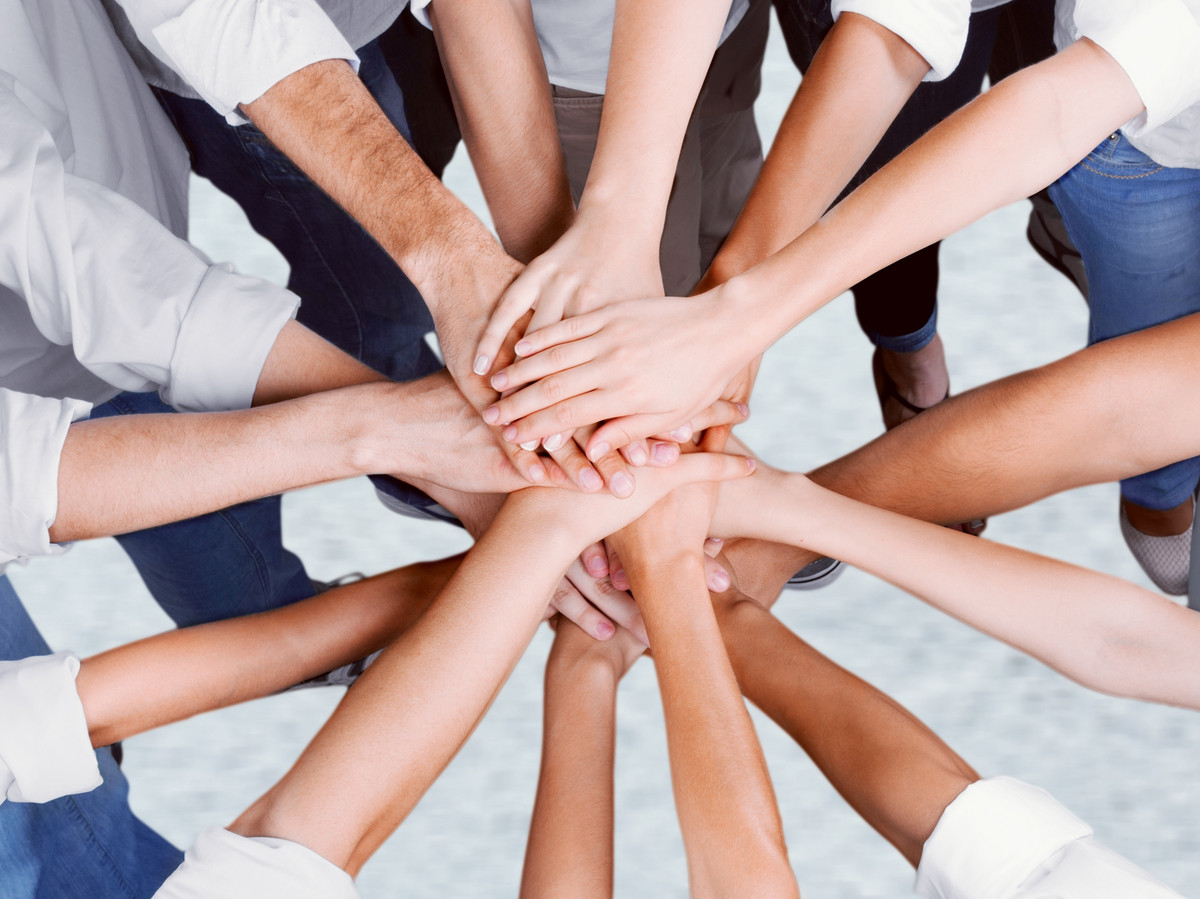 Hände aufeinandergelegt: Teamwork bei manQ