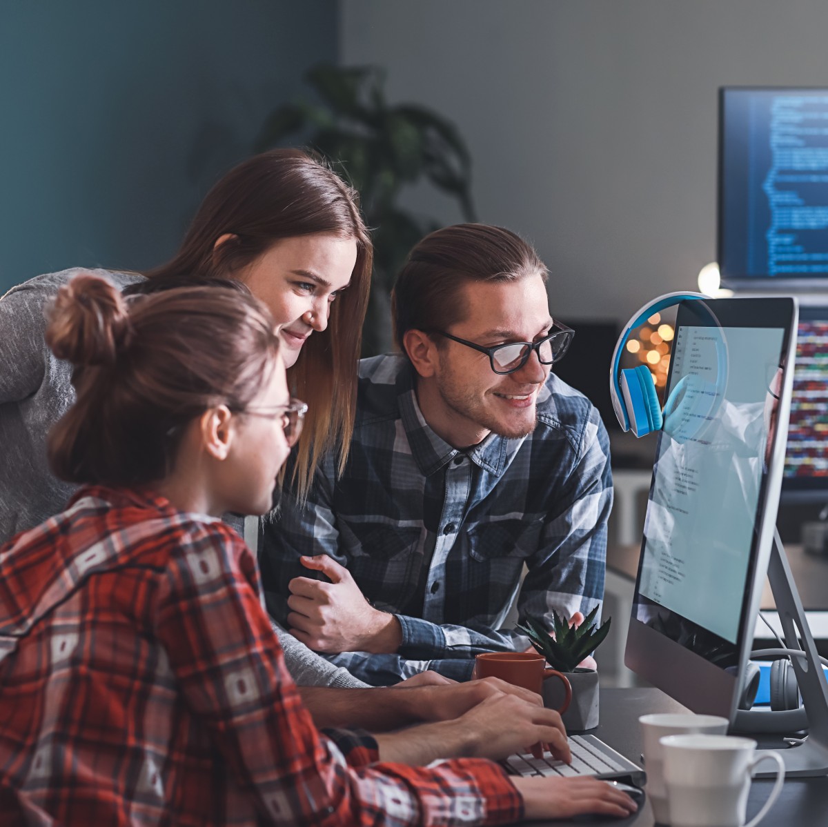 Gruppe von Auszubildenden in der IT-Branche sitzen vor Rechner/Bildschirm