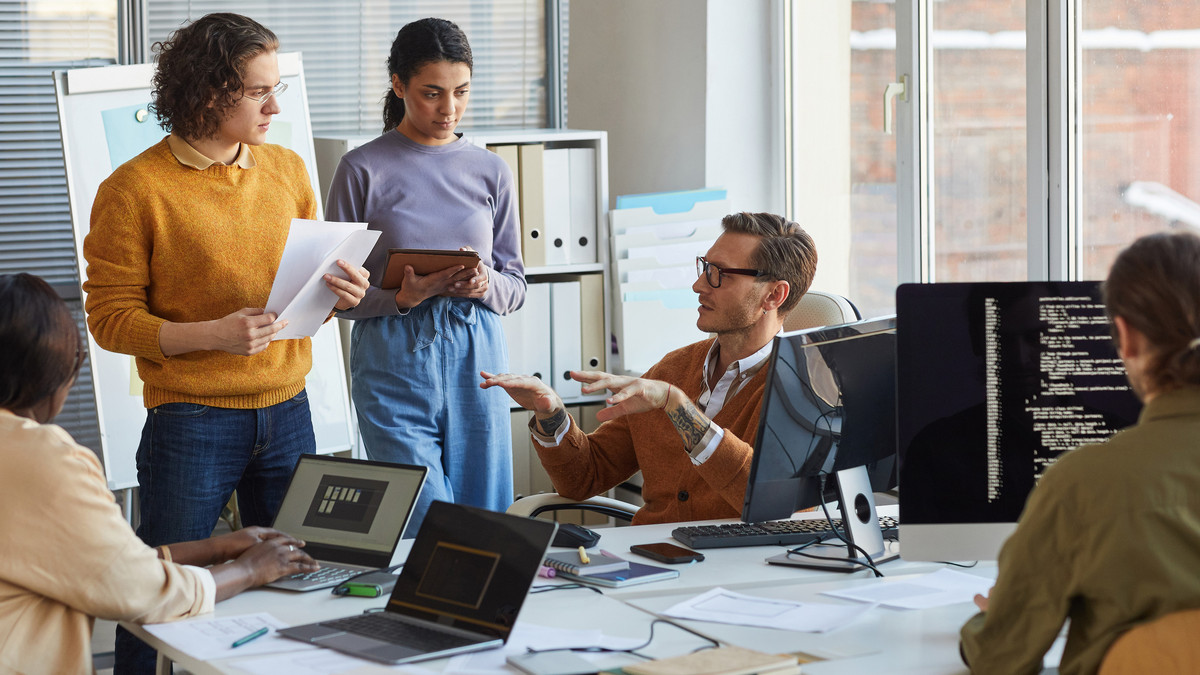 Gruppe von IT-Experten im Gespräch: Online-Fortbildung Bachelor Professional in IT bei manQ
