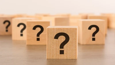 FAQ - Häufig gestellte Fragen Holzwürfel mit Fragezeichen: FAQ zu Aufstiegsfortbildungen von manQ