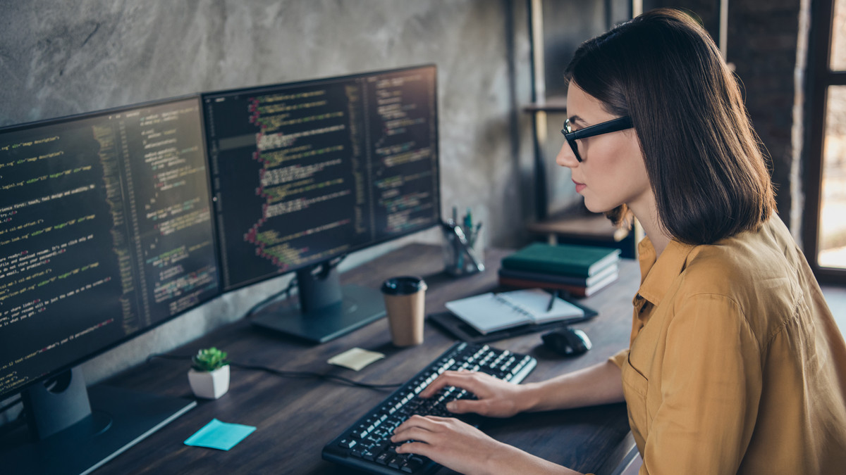 Frau sitzt vor Monitoren: Online-Fortbildung Berufsspezialist für Systemintegration und Vernetzung bei manQ