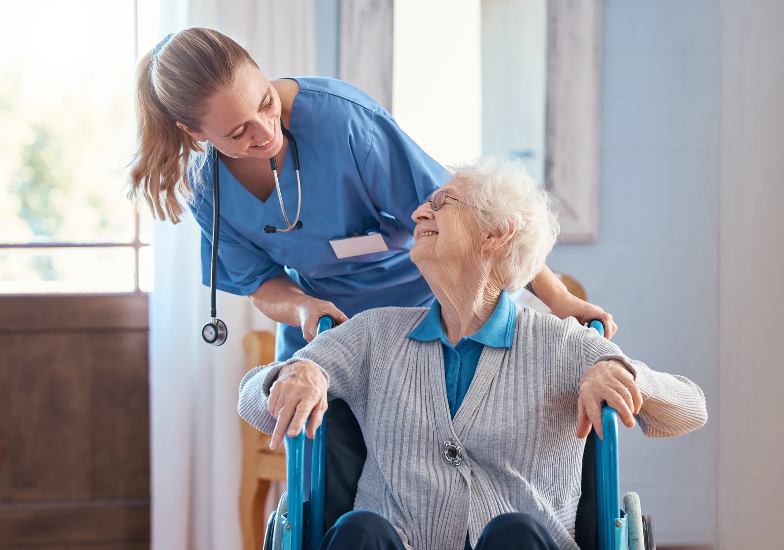 Zulassung zur IHK-Prüfung prüfen Beschäftigter im Gesundheits- und Sozialwesen mit Unterlagen auf dem Flur einer Pflegeeinrichtung.