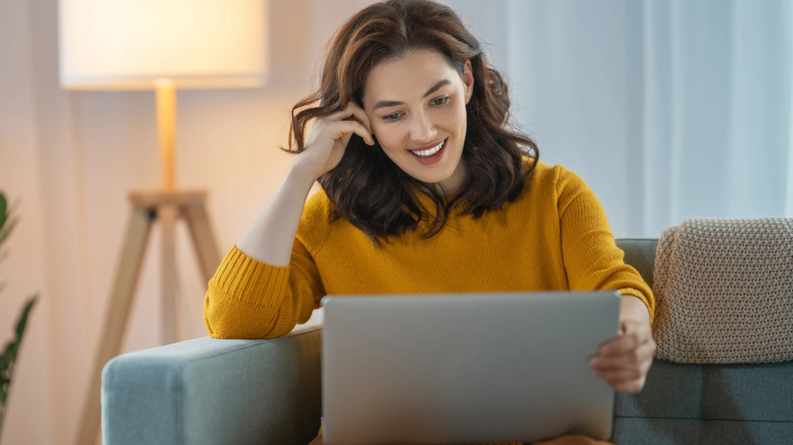Frau sitzt vor dem Laptop, um Fragen zum kostenfreien Online-Infoabend zu klären